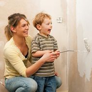 Frau und Kind streichen Wand